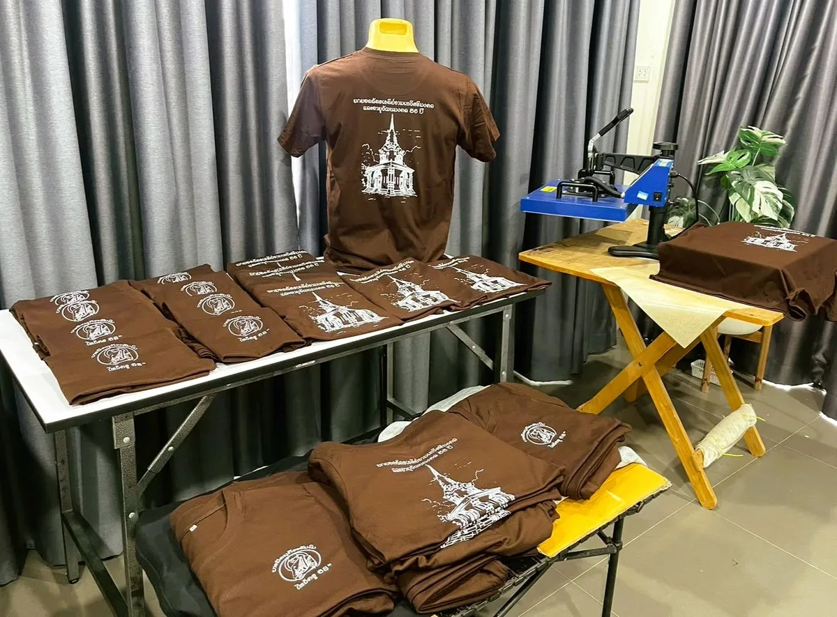 หน้าร้านบ้านเสื้อ พร้อมเครื่องรีดร้อนและเสื้อที่ผลิตเสร็จ